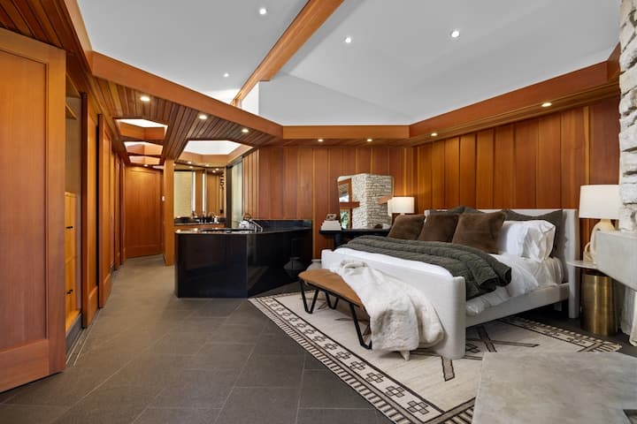 Unwind in your luxurious bedroom suite featuring rich wood finishes, a cozy fireplace, and elegant modern amenities for the perfect retreat.