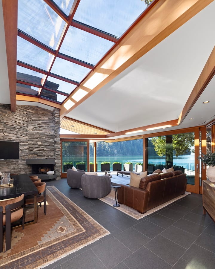Relax in this stunning glass-ceiling living room where natural light floods your space and panoramic lake views create the perfect backdrop for your getaway.