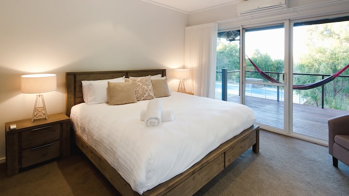 主卧套房配备一张加大双人床和一间宽敞的步入式衣帽间，让您的空间保持整洁。