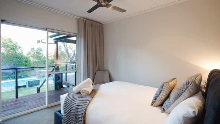 在第四间卧室中，一张标准双人床和一扇通往露台的滑动门与室外无缝连接。