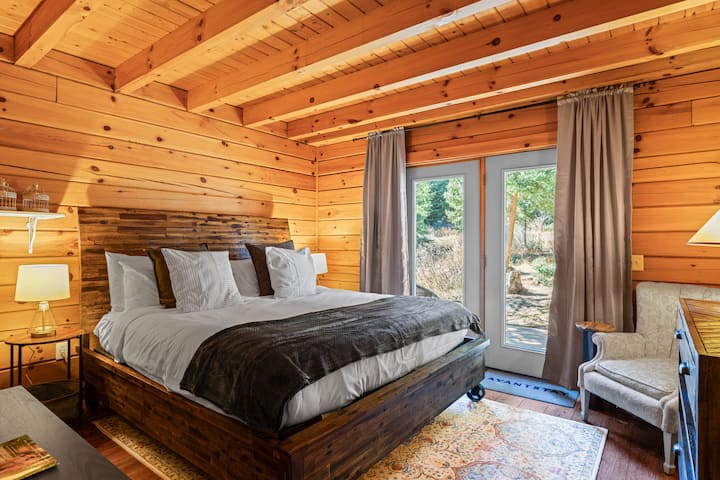 Quarto principal com cama king size, TV e acesso ao pátio privativo.
