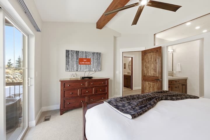 Dormitor principal cu accente de lemn și lumină naturală:
Apartament primar spațios, cu tavane cu grinzi din lemn, ferestre mari și mobilier cald, care îmbină confortul cu eleganța montană.