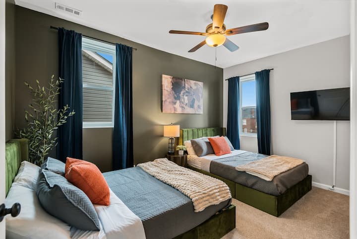 Suite de invitados moderna: disfruta de comodidades de primera calidad que incluyen lujosa ropa de cama, iluminación integrada junto a la cama y una gran pantalla plana para una experiencia cinematográfica privada.