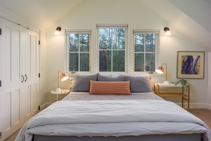 חדר שינה רגוע ונעים עם תאורה רכה ונוף שקט ליער ללילות שלוים.