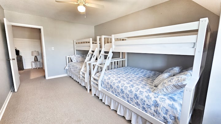 Habitación en el segundo piso con dos camas individuales sobre una cama queen en litera