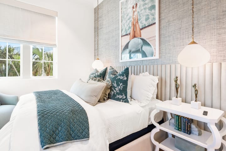 Opustite se u svojoj spokojnoj spavaćoj sobi s dekorom inspirisanim obalom, mekom posteljinom i tropskim pogledom kroz prozor.