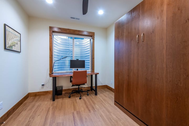 Flexible bedroom with Murphy bed and dedicated workspace.
