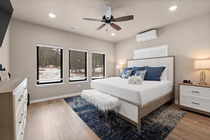 พักผ่อนอย่างสบายในห้องพักกว้างขวางพร้อมการตกแต่งสีน้ำเงินอ่อน หน้าต่างบานใหญ่ และเครื่องนอนที่อบอุ่น