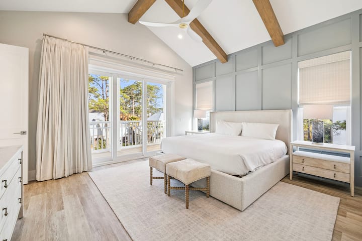 Relájate en tu apacible dormitorio, un verdadero santuario con techos altos, cálidas vigas de madera y vistas tranquilas a los árboles desde tu balcón privado.
