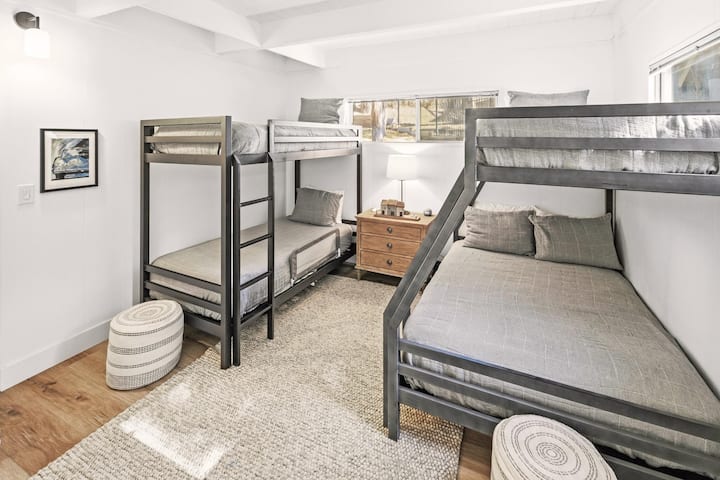 Dos literas: una litera con dos camas individuales y otra con una cama individual y una cama de plaza y media