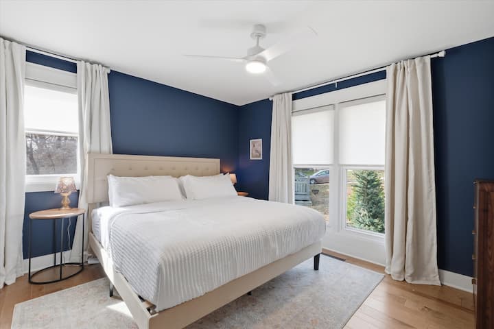 Hlavná spálňa s manželskou posteľou veľkosti King s mäkkou posteľnou bielizňou, jemným osvetlením a krásnym prirodzeným svetlom. Pokojný, súkromný priestor určený pre pokojné noci v The Regency.