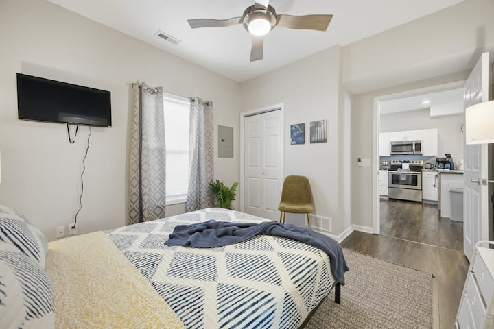 Udobna spavaća soba s TV-om, stropnim ventilatorom i izravnim pristupom modernoj kuhinji A