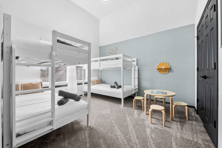 Divertida habitación con literas con varias camas y una zona de juegos para niños, perfecta para familias y grupos más grandes.