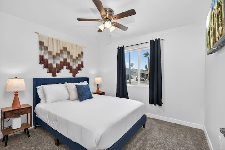 חדר שינה מואר ומזמין עם מיטת קווין סייז.