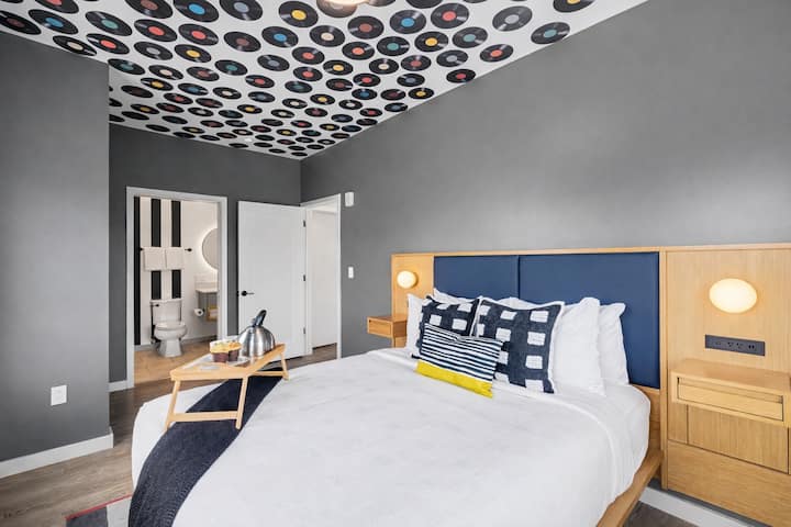 1号房源：主卧设有一张标准双人床、智能电视、内置衣柜和套房卫生间。