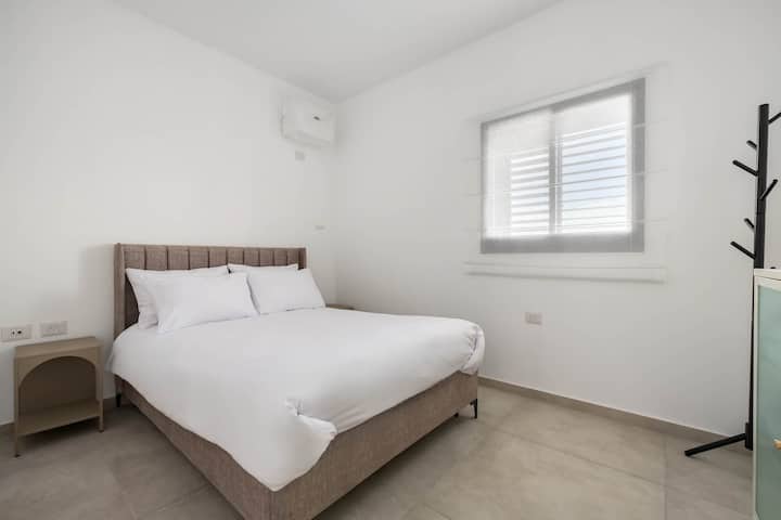 Svijetla spavaća soba za goste nudi privatnost, jednostavnu eleganciju i udobno okruženje za opuštanje i odmor.