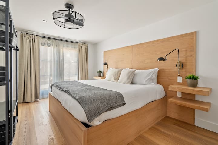 Relax and recharge in a serene bedroom with soft natural light and a plush king bed designed for restful nights.