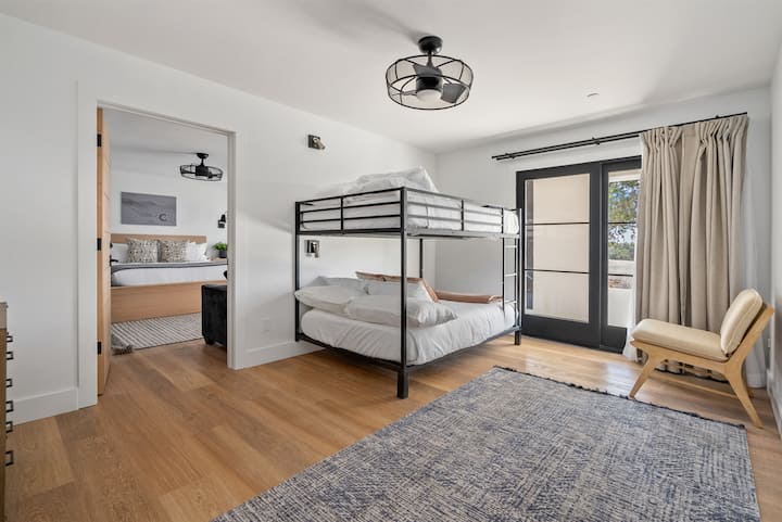 A versatile space with metal twin bunks and puffy mattresses that opens directly into the adjacent suite for a shared layout where guests feel connected.