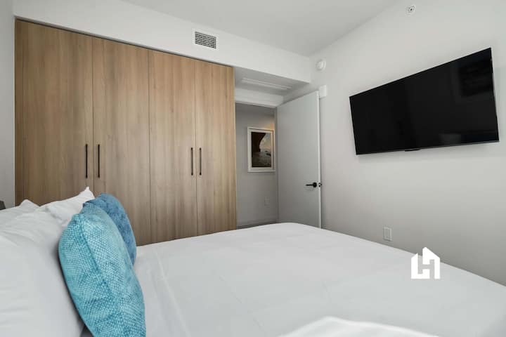 Dormitorio tranquilo con televisión y espacio de almacenamiento empotrado.