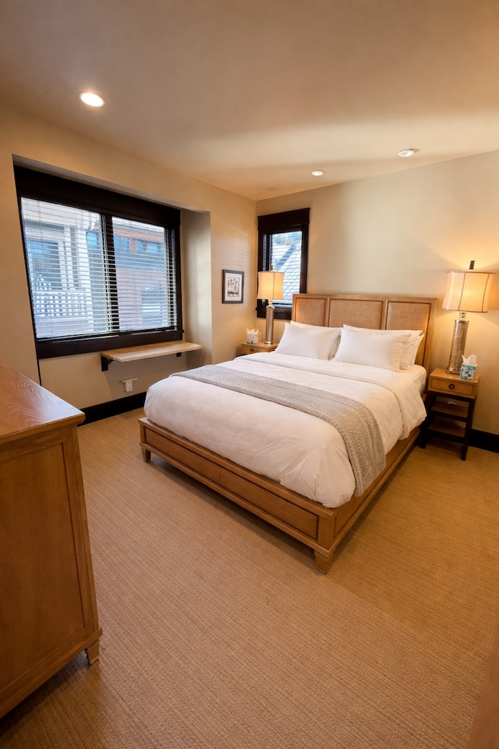 תיהנו משנת לילה שלווה בחדר השינה המזמין הזה עם תאורה רכה, גימורים בהשראת הרים והרבה אור טבעי.