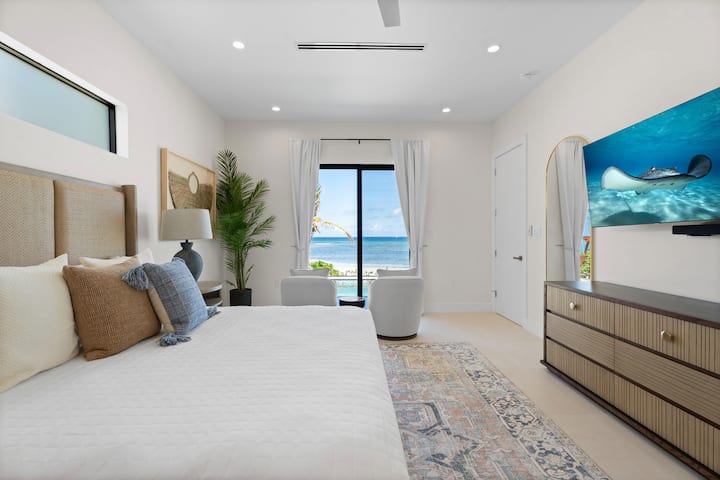 El dormitorio 1 cuenta con una cama king, televisor de alta definición y acceso directo a la terraza de la piscina.