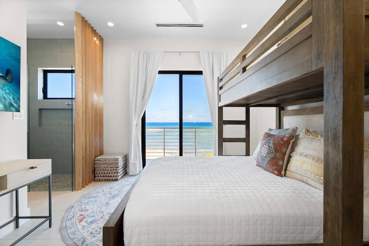 El dormitorio 3 cuenta con una cama queen sobre una litera individual, un televisor de alta definición y acceso directo al balcón con vista al mar.
