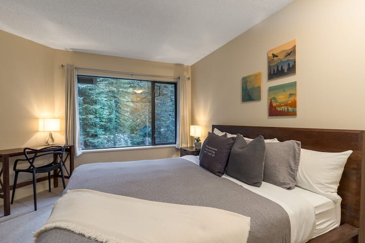 明亮安静的次卧，配有一张加大双人床，可欣赏森林景观。
