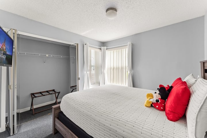 Dormitorio con temática Mickey y Minnie con una cama tamaño queen y un televisor.