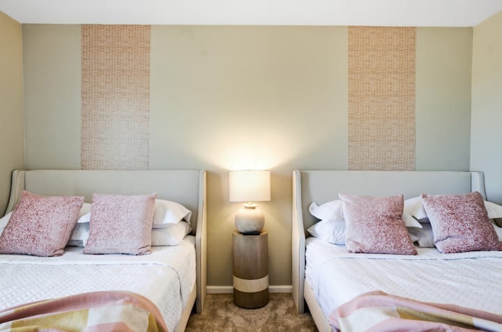 Amplio dormitorio en tonos suaves con ropa de cama acogedora, ideal para relajarse.