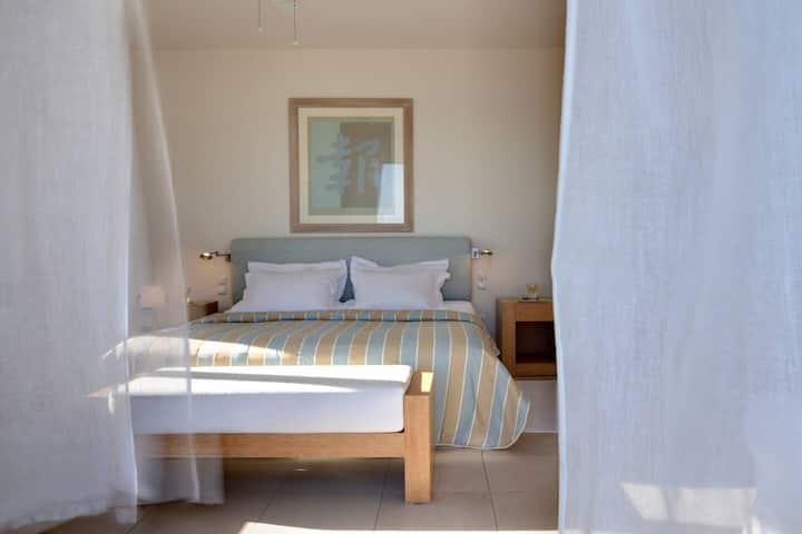 Главна спалня с голямо двойно легло, което се отваря на голям балкон с диван, за да се насладите на спиращата дъха гледка към морето