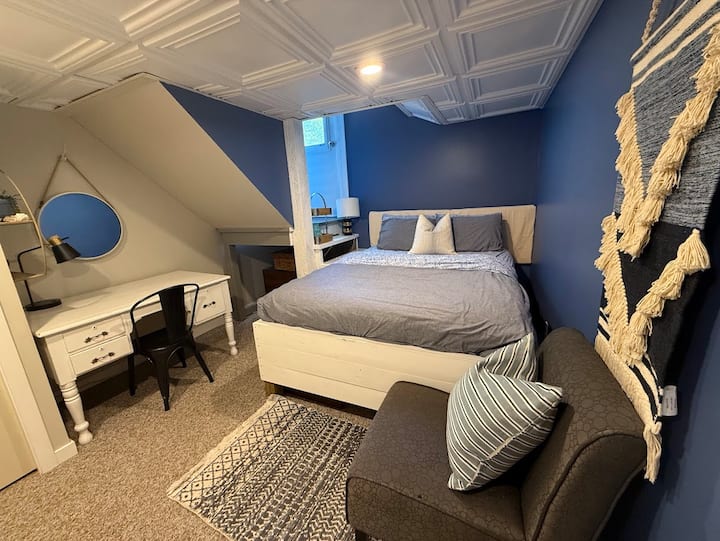 غرفة النوم 1: غرفة نوم بحجم كوين غير تقليدية بشكل مبهج، تتميز بمكتبة "خذ كتابًا، اترك كتابًا".