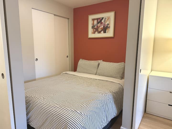 Bed alcove with queen bed and bedside shelf