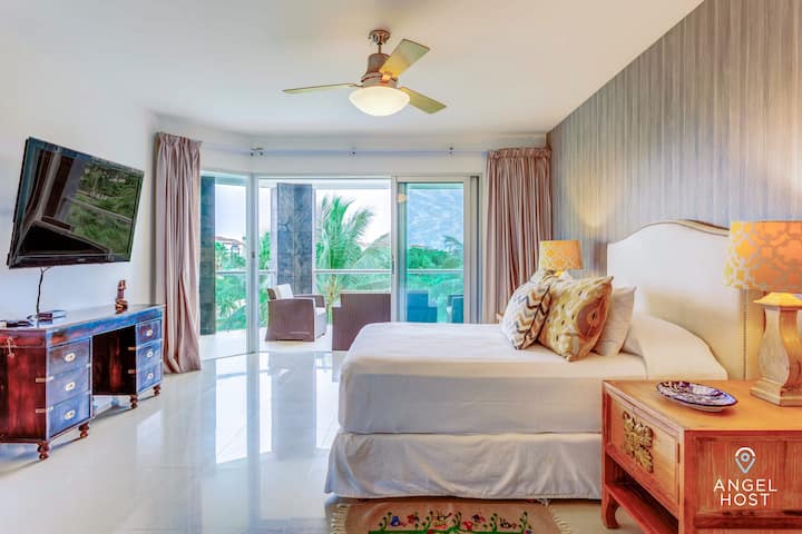 Dormitorio 1 con cama tamaño queen, televisor inteligente y acceso directo a la terraza