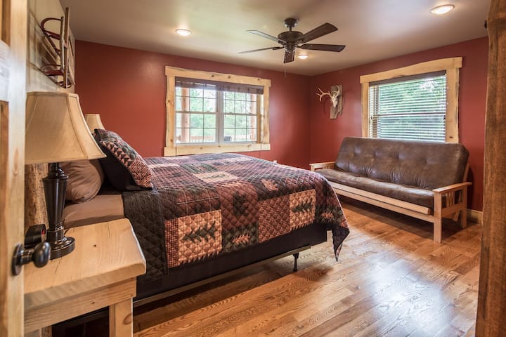 Спална соба на главниот кат со брачен кревет и футон во целосна големина.