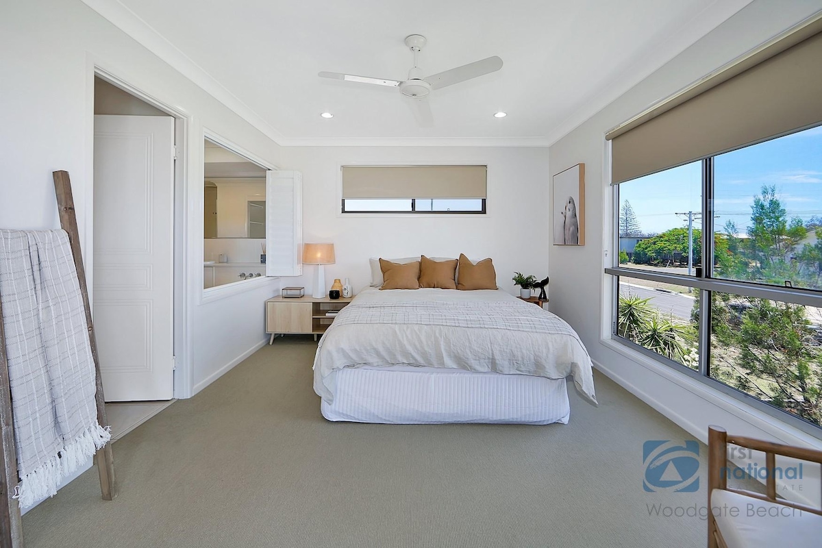 宽敞的主卧室，配有吊扇 