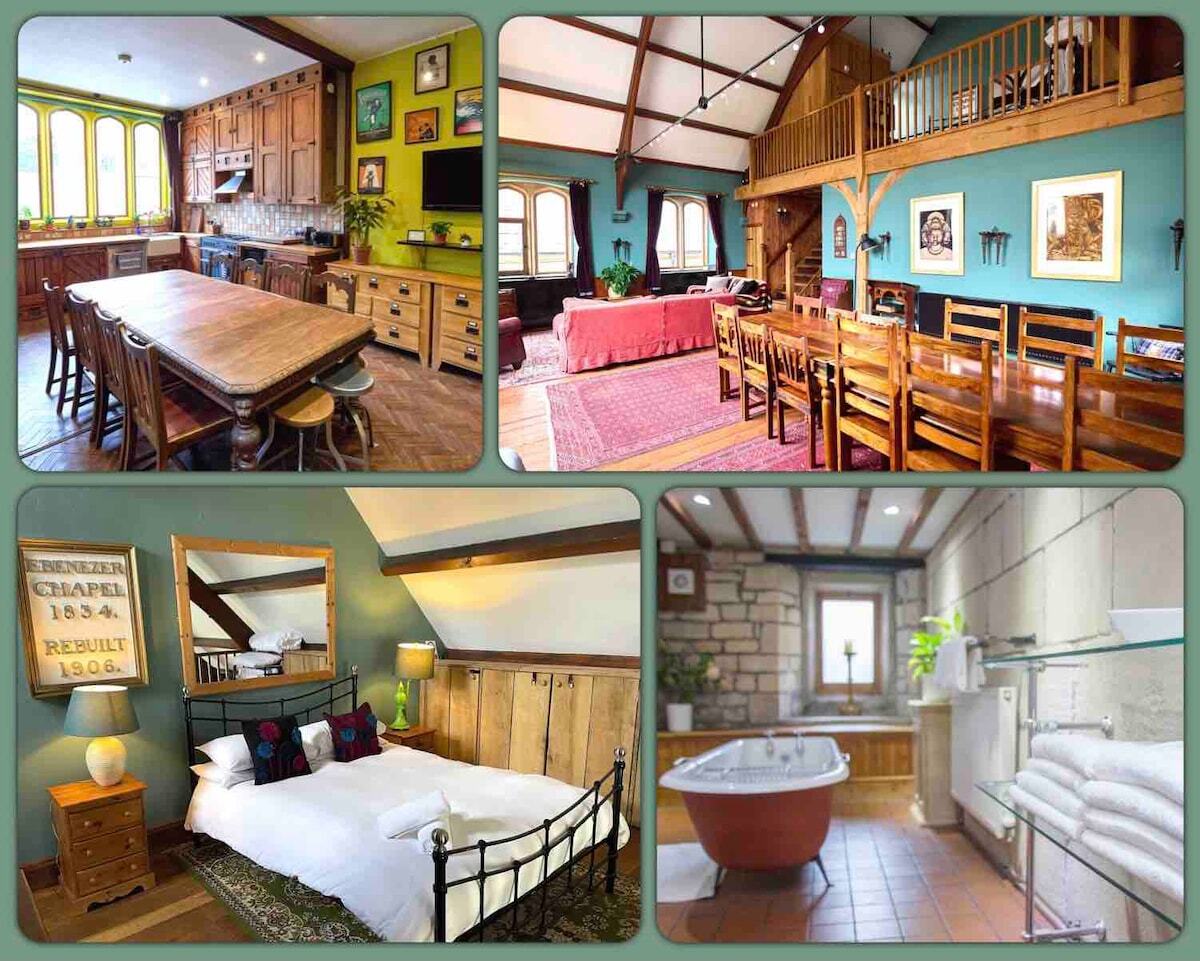 An open-concept kitchen and dining area showcases a large wooden table surrounded by multiple chairs, complemented by warm wooden cabinets and appliances. Adjacent, a cozy living room features a vibrant rug and seating, while the bathroom displays a freestanding tub against a stone wall, with natural light illuminating the space.