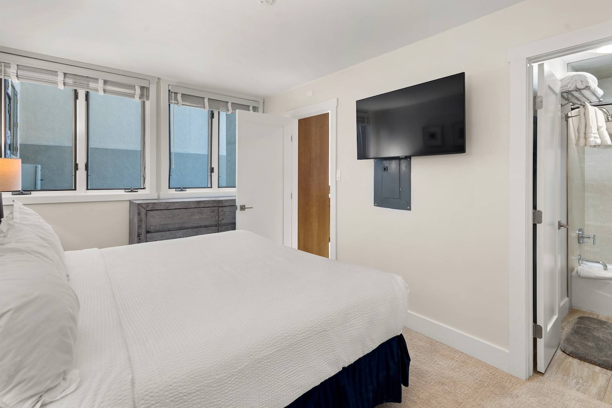 בחדר השינה הראשי עם מיטת הקינג סייז יש טלוויזיה עם מסך שטוח וחדר רחצה צמוד עם אמבטיה ומקלחת