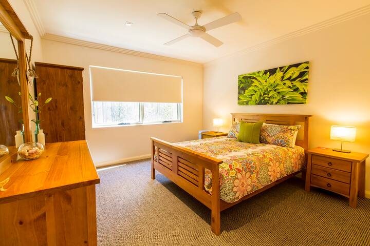 ห้องนอนควีนไซส์แรกเป็นสถานที่พักผ่อนที่อบอุ่นและมีสีสันพร้อมเฟอร์นิเจอร์ไม้ที่อบอุ่นและแสงธรรมชาติเพื่อการพักผ่อนที่ดีที่สุด