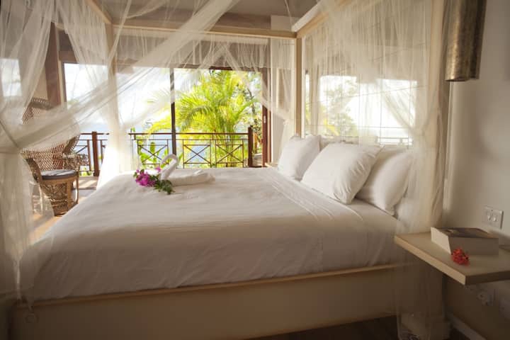 Suite de lujo primaria YELLOW FLAMBOYANT con cama tamaño king y jacuzzi. Con aire acondicionado, ventilador, mosquiteras, TV y base de música.