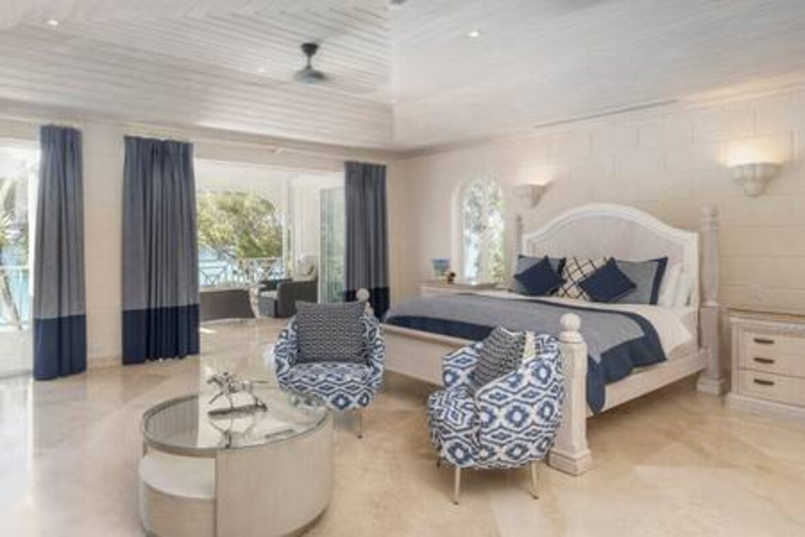 The master suite offers generous space to unwind, plus a shared balcony with Bedroom 2. Features include air conditioning, ceiling fan, TV, Sonos, safe, walk-in wardrobe, and an en suite with freestanding bath and separate shower.