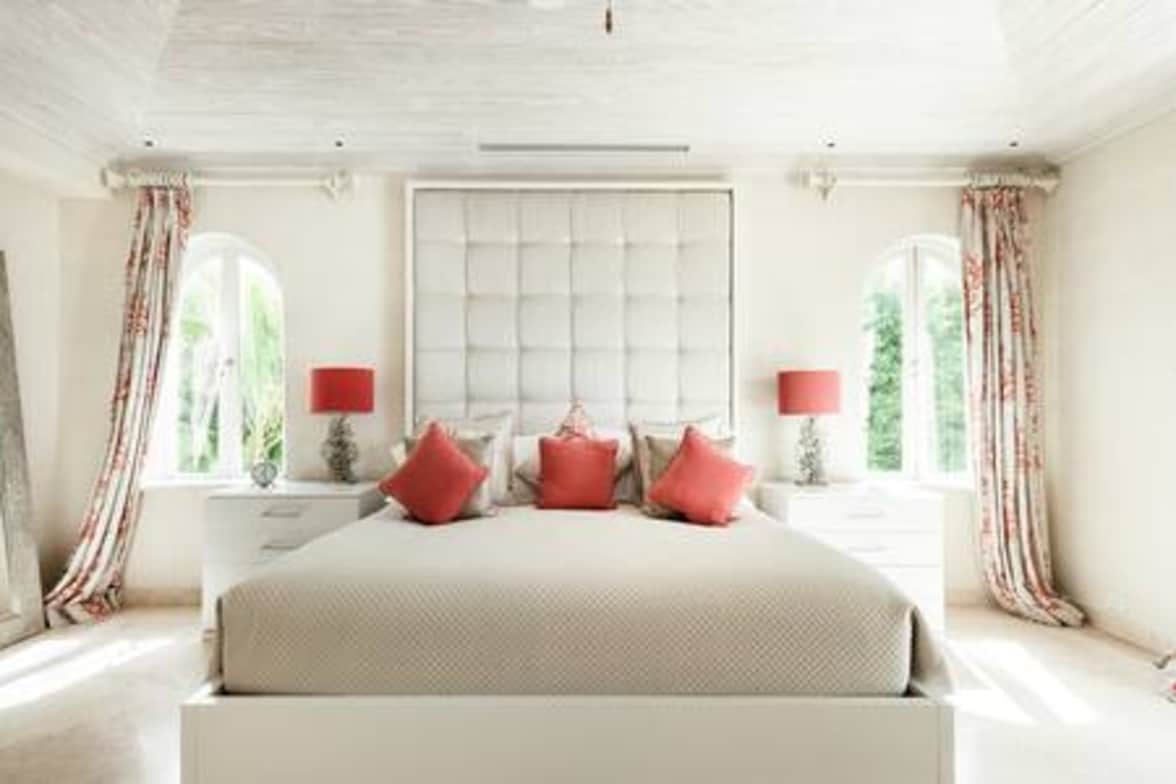 Un dormitorio principal luminoso y espacioso con vistas en tres lados, entre ellos la impresionante vista al mar a través del balcón privado.  La habitación también cuenta con una cama tamaño king de EE. UU., aire acondicionado, ventilador de techo, TV inteligente, caja fuerte, vestidor y baño privado.