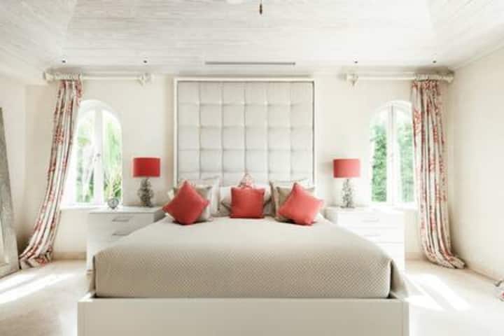 Een lichte en luchtige hoofdslaapkamer met uitzicht aan drie zijden, niet in de laatste plaats het prachtige uitzicht op zee via het eigen balkon.  De kamer beschikt ook over een Amerikaans kingsize bed, airconditioning, plafondventilator, smart-tv, kluis, inloopkast en een eigen badkamer.