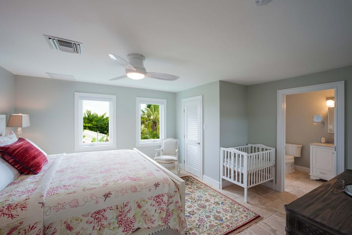 Apartament gościnny na wyższym poziomie z łóżeczkiem dziecięcym.