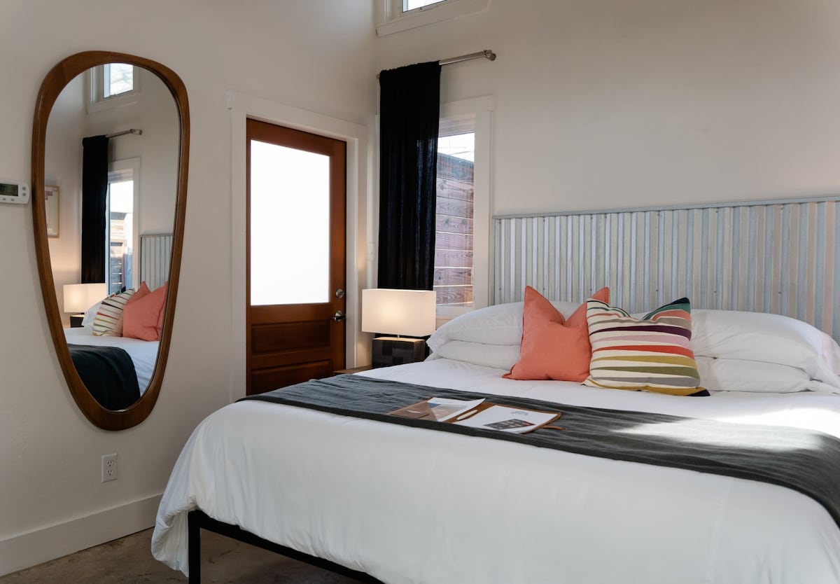 Bedroom with king bed – luxe linens, modern décor, and private courtyard access.