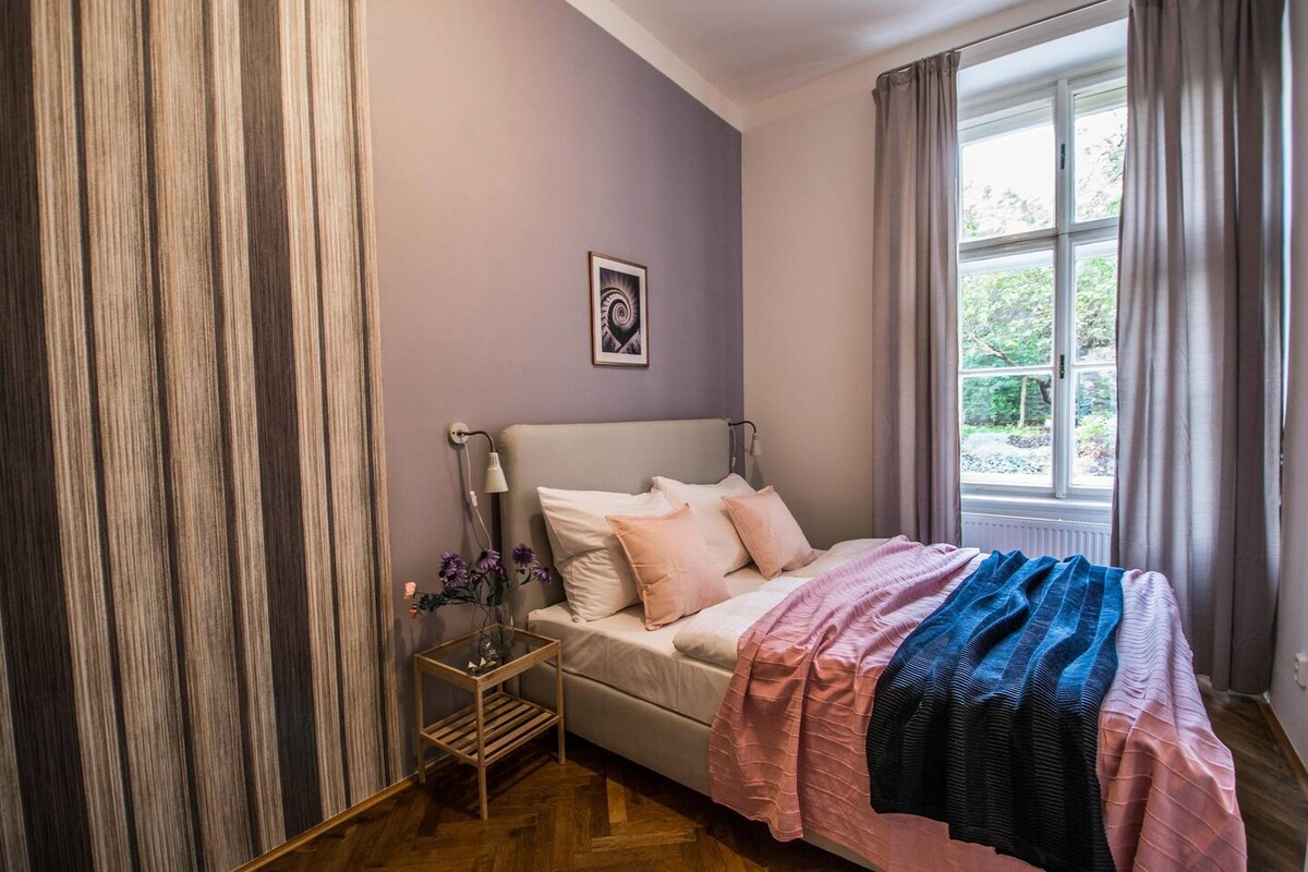 ห้องนอนที่ 2 พร้อมเตียงควีนไซส์ขนาดใหญ่และวิวสวน