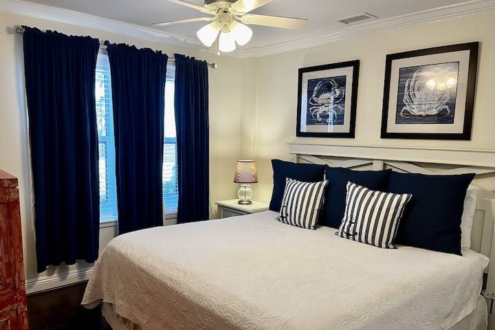 Dormitorio de invitados con cama tamaño king con ropa de cama costera de temática náutica