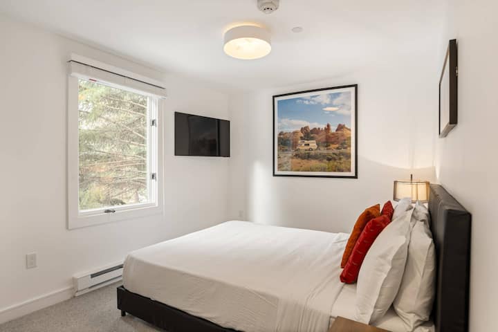 The second bedroom has a queen bed and flat screen smart TV.