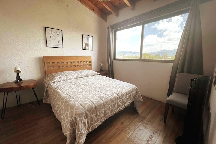 recámara secundaria con vistas al pueblo, ofreciendo un refugio personal de confort y tranquilidad