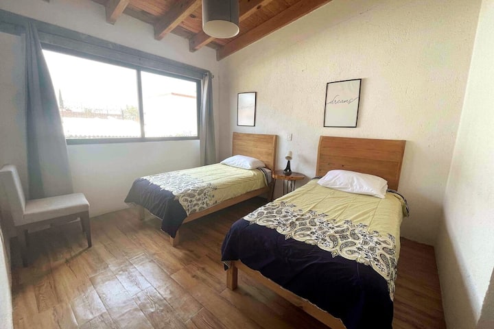 Segunda recamara con camas individuales y vista panorámica al pueblo