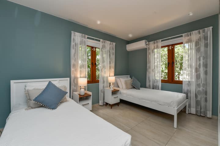 Gloriosa habitación con camas individuales de la villa en Noord, Aruba - Cómodas 2 camas individuales - Habitación elegantemente pintada con paredes bellamente pintadas con combinación de colores estéticos - Lámparas de mesa majestuosas - Ropa de cama ordenada y limpia con almohadas suaves